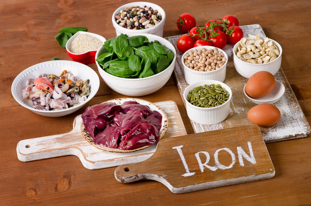 A display of iron-rich foods, such as eggs, liver, spinach, shrimp, tomatoes, and nuts